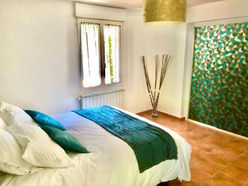 a bedroom with a bed and a painting on the wall at Domaine Plan des Devens in Roussillon