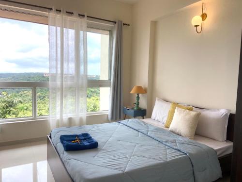 a bedroom with a bed and a large window at Platinum - Sun-kissed Holidays Goa in Dabolim