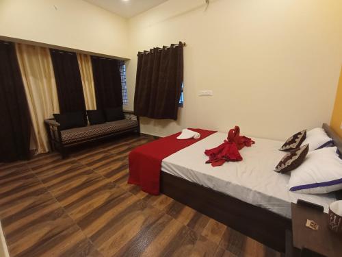 a room with a bed and a chair in it at Arangan Kudil in Tiruchchirāppalli