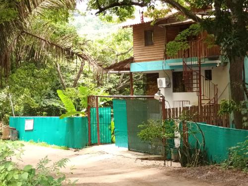 a house with a green gate in front of it at Mundaka : Burnt Toast Surfcamp in Nosara