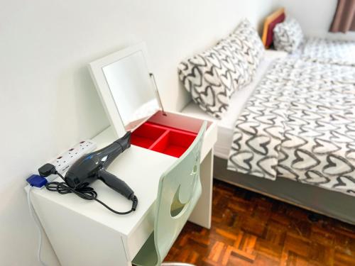 a bedroom with a desk with a hair dryer and a bed at BayView Suites Port Dickson By MAISON in Port Dickson