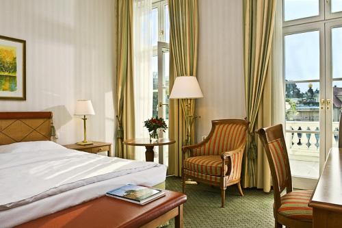 Habitación de hotel con cama, silla y ventana en Hotel Am Jägertor en Potsdam