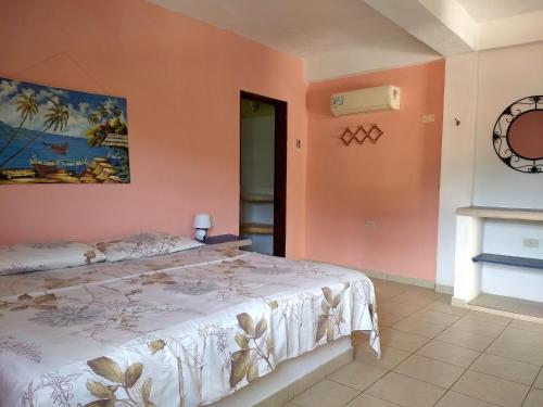 a bedroom with a bed and a clock on the wall at Villa Cocuyo - Studios & Apartments in El Cardón