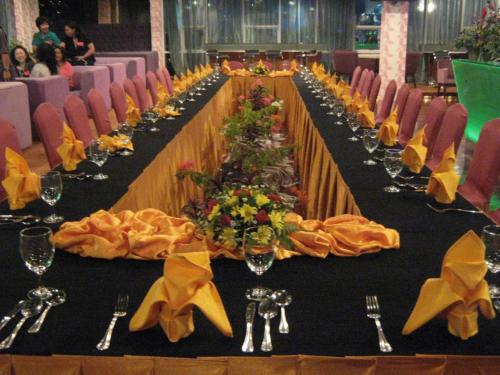 a long table with chairs and wine glasses at Courtyard Hotel 1Borneo in Kota Kinabalu
