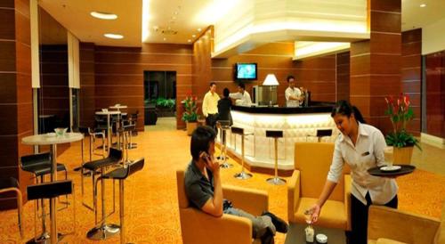 two women sitting in chairs in a hotel lobby at Courtyard Hotel 1Borneo in Kota Kinabalu