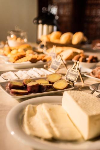 a table topped with plates of food on top at Pousada Tapera in Penedo