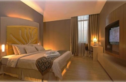 a hotel room with a bed and a television at Courtyard Hotel 1Borneo in Kota Kinabalu