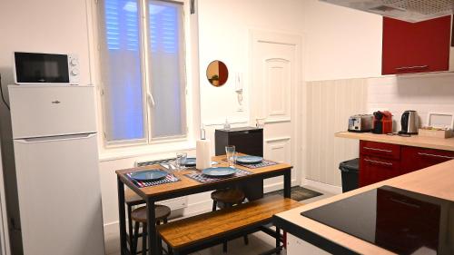 een keuken met een kleine tafel in een keuken bij VINTAGE Maison 9mn Astérix Chantilly 15mn Aeroport CDG in Survilliers