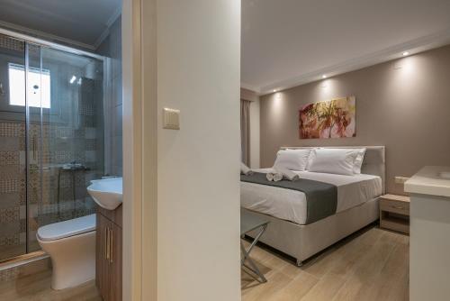 a bedroom with a bed and a bathroom with a shower at OLYMPIA ROOMS in Myrina