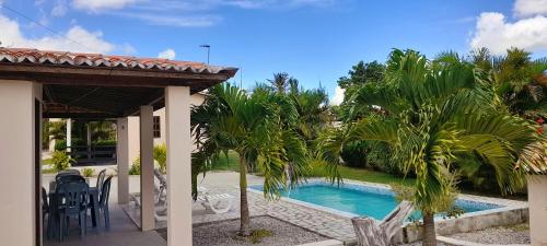 a house with a swimming pool and palm trees at Pousada Vale Encantado in Serra de São Bento