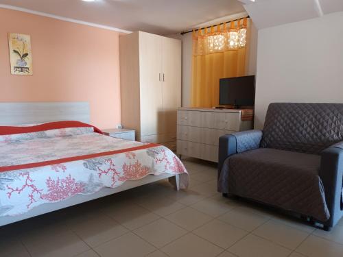 a bedroom with a bed and a chair and a television at Mare e relax in Tropea