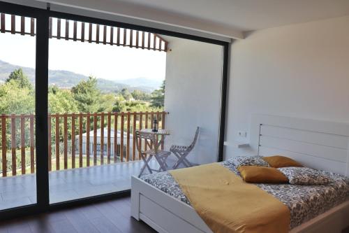 1 Schlafzimmer mit einem Bett und einem Balkon mit Aussicht in der Unterkunft Casa João Eusébio 3 in Ponte de Lima