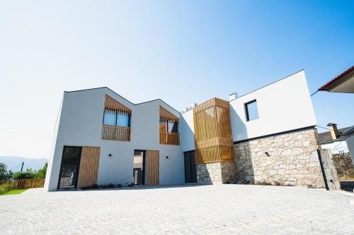 a white house with wooden windows and a driveway at Casa João Eusébio 3 in Ponte de Lima