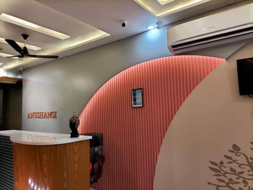 an office with a red wall and a ceiling at Anushangi Hotel in Hisār