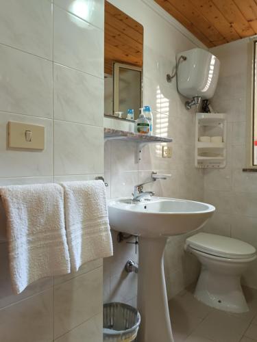 a white bathroom with a sink and a toilet at Mare e relax in Tropea