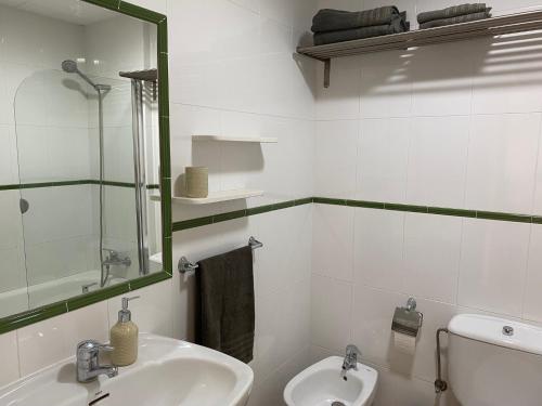 y baño con lavabo, espejo y aseo. en Luminoso apartamento en Canet de Mar cercano a la playa y a Barcelona, en Canet de Mar