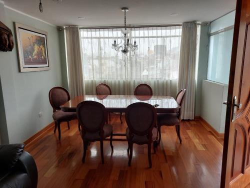 a dining room with a table and chairs and a window at Departamentos Las Lilas Surco Lima in Lima