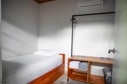 a bedroom with a white bed and a wooden table at Wao Jungle Venao in Playa Venao