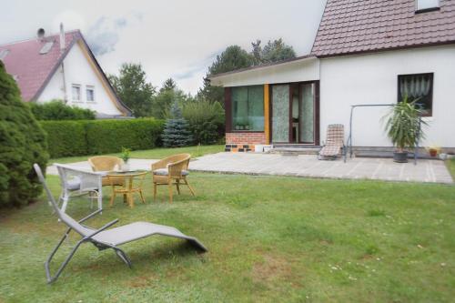 a patio with a table and chairs in a yard at Pension Zum Taucher in Gosen
