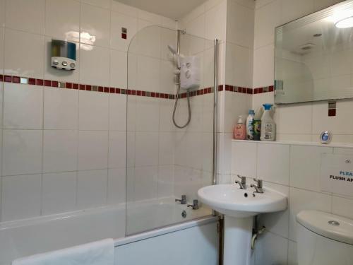 a bathroom with a shower and a sink and a toilet at Liverpool City Centre Private Rooms including smart TVs - with Shared Bathroom in Liverpool