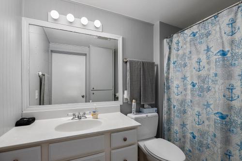 La salle de bains est pourvue d'un lavabo, de toilettes et d'un miroir. dans l'établissement Waterfront Suite centrally located w/ private dock, à Newaygo