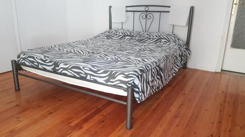 ein Bett mit einer schwarzen und weißen Bettdecke darauf in der Unterkunft SIXORIZON NEW PRIVATE APARTMENT IN THESSALONIKI IPPOKRATEIO gr in Thessaloniki