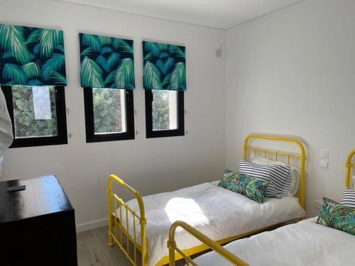 Cette chambre comprend 2 lits, une table et des fenêtres. dans l'établissement Paphos luxury contemporary villa, à Paphos