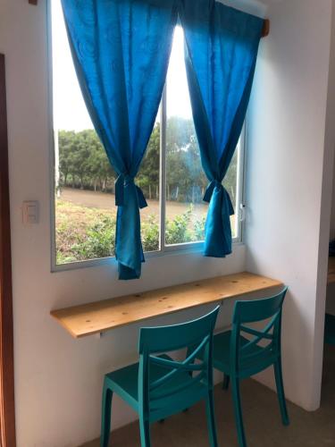 uma mesa e duas cadeiras em frente a uma janela em EL JARDIN OLON SUITES em Olón