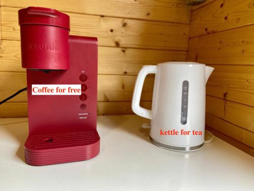 - Cafetera roja y hervidor de agua para el té en Algonquin Madawaska Lodge Cottage Glamping Cabins, en Madawaska