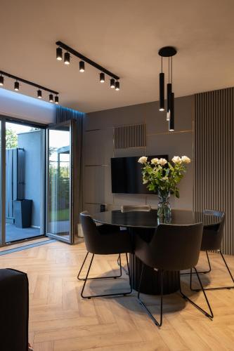 a dining room with a table with a vase of flowers at Apartament Zwirki in Toruń