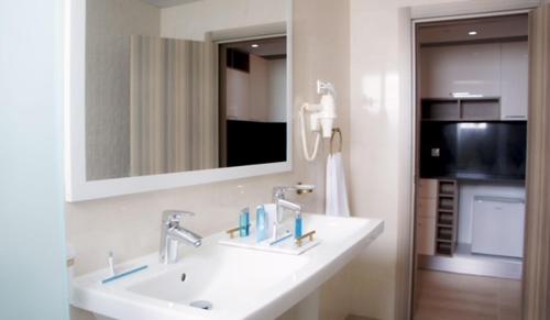 a bathroom with a white sink and a mirror at Hotel Delphin-Nouadhibou in Nouadhibou