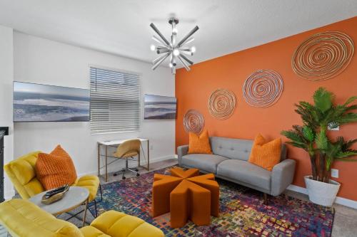 sala de estar con paredes de color naranja, sofá y sillas en Beautiful Family Villa - Pool and Hot Tub - Near Disney World en Kissimmee