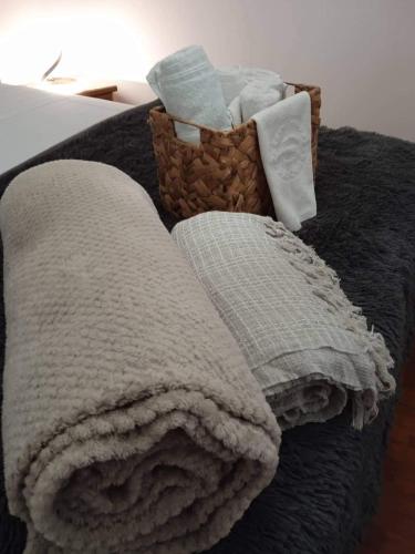 a blanket and a basket of towels on a bed at Adorable Cozy Apartment in Aglantzia