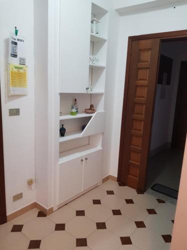 ファレルナにあるCasa giuseppeの白いキャビネットとドアが備わるタイルフロアの客室です。