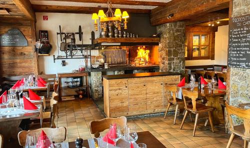 a restaurant with tables and chairs and a fireplace at Hotel Les Chamois in Verbier