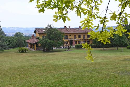 a large house on a grassy field in front thereof at La Cà dOlga in La Morra