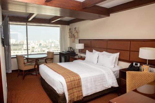 Habitación de hotel con cama, mesa y ventana en Casa Andina Premium Miraflores, en Lima