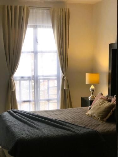 a bedroom with a bed and a large window at Gualdras Departments with parking 7min to downtown in Guanajuato