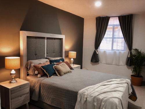 a bedroom with a bed and two lamps and a window at Gualdras Departments with parking 7min to downtown in Guanajuato