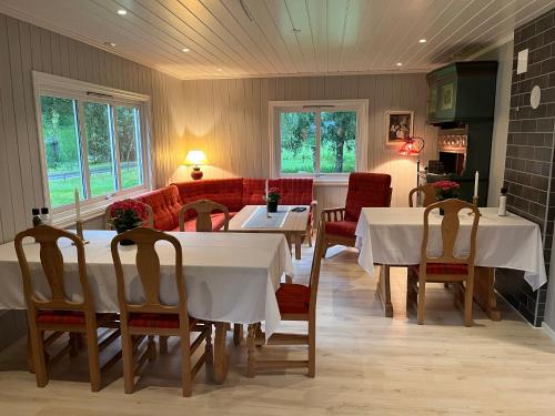 uma sala de jantar com mesas e cadeiras brancas em Nørdre-Repp em Boverdalen