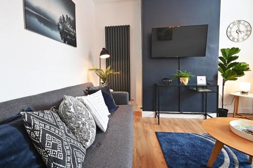 a living room with a couch and a tv at The Coffee Pot Cottage in Town Centre FREE Parking in Stratford-upon-Avon