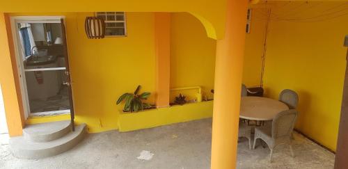 a dining room with a table and a yellow wall at Casa De Amor Suites and Tours 