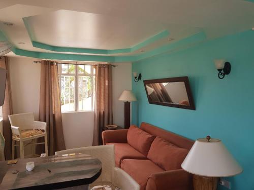sala de estar con sofá y paredes azules en Casa De Amor Suites and Tours 