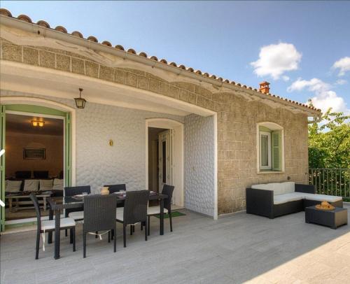 a patio with a table and chairs and a building at Casa santoni 20 in Grosseto-Prugna