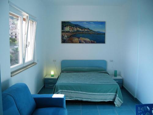 - une chambre avec un lit et un canapé bleu dans l'établissement I Fiori di Donna Ester, à Pisciotta