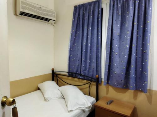 a small bedroom with a bed and a window with stars at SAN REMO HOSTEL in Athens