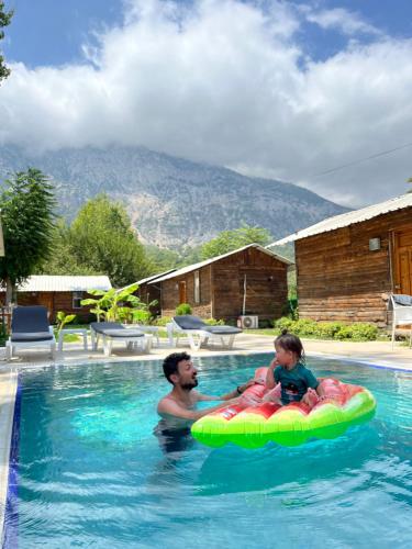 a man and a child on a raft in a swimming pool at Lime tree houses in Beldibi