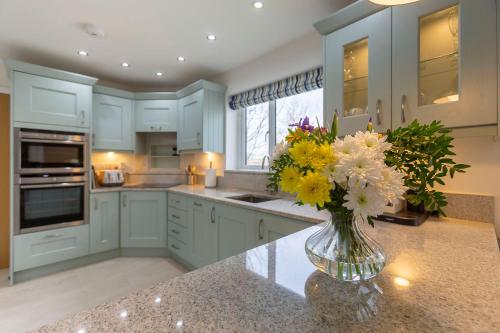 a kitchen with a vase of flowers on a counter at The Grove - Bude Cornwall in Bude