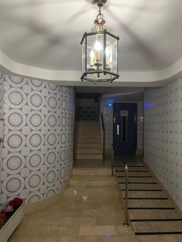un corridoio con scale e lampadario a braccio in un edificio di Spanish Sunrise a Benidorm