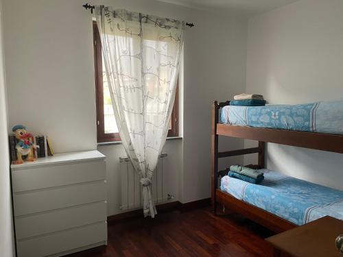 a bedroom with two bunk beds and a window at La casa del Conte - Feriolo di Baveno con giardino privato in Baveno